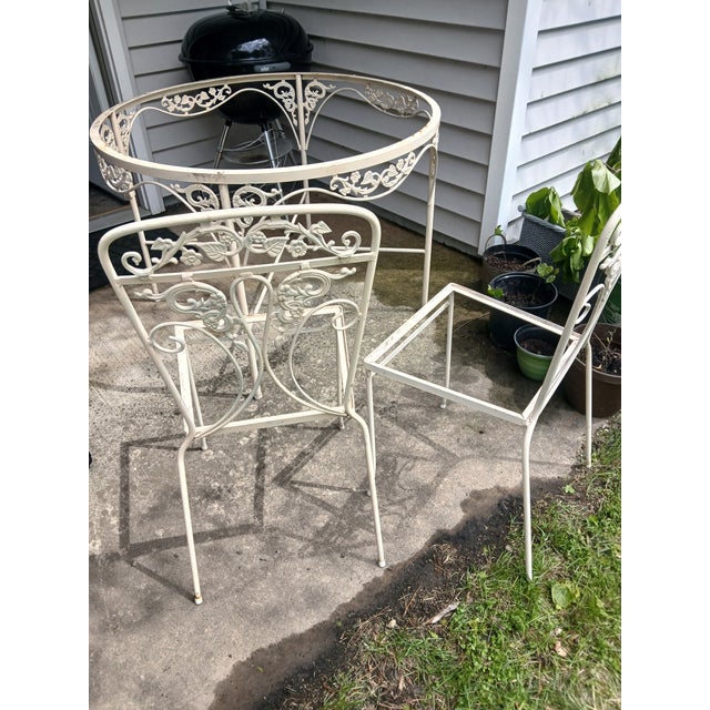 Vintage 1960s wrought iron Patio Dining Set. 4 chairs, one table. Glass top included. 41" diameter table. Original...
