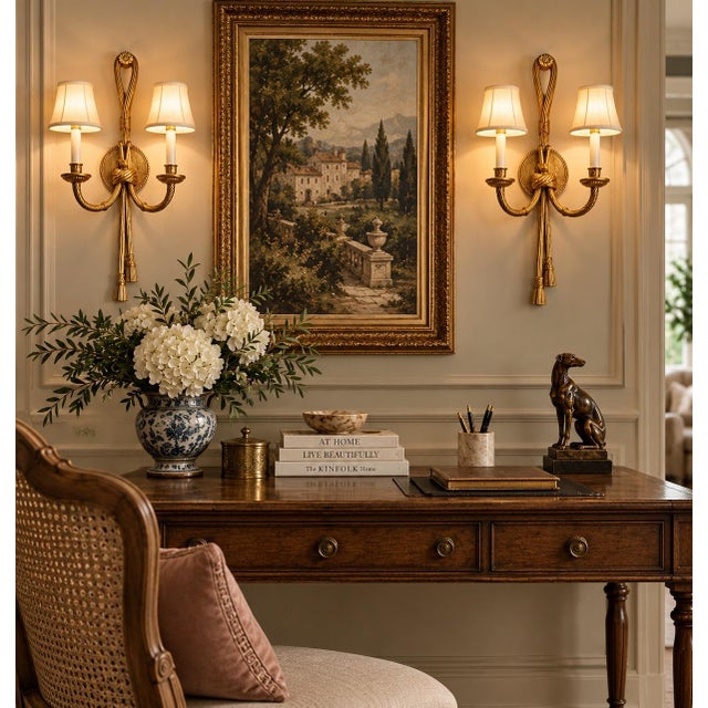 Beautiful pair of vintage Regency-style gilt wall sconces featuring an elegant rope-and-tassel design. Each sconce has two...