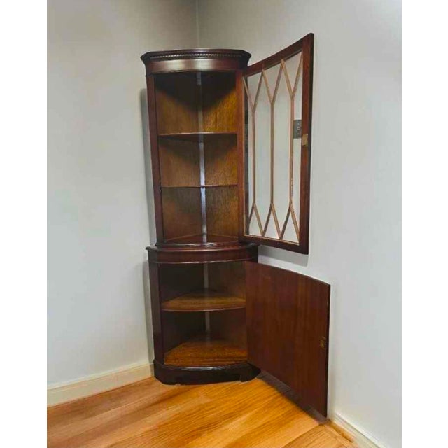 A gorgeous corner cabinet Made in England, wonderful mahogany wood. The upper curved door has individual arched glass...