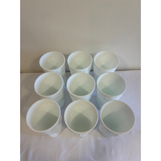 A charming set of nine vintage white milk glass tumblers featuring an embossed grape and vine motif. Raised clusters of...