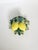 A charming decorative glazed ceramic sculpture featuring a pair of yellow lemons surrounded by abundant foliage in various...