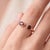 A bold, contemporary open-cuff ring featuring two rich red garnets, each round-cut and held in a smooth bezel setting. The...