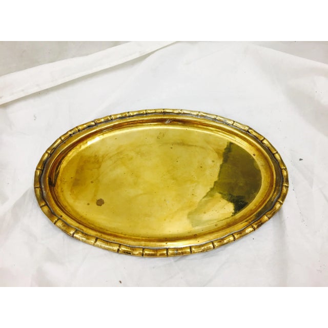 Beautiful vintage brass tray is oval shaped with stunning faux bamboo trimmed edge. Some slight oxidation with age.