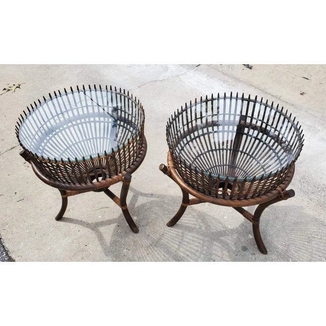 Availble are a pair of Franco Albini Fish Trap glass top tables with a bamboo base. These MCM rattan and glass tables are...