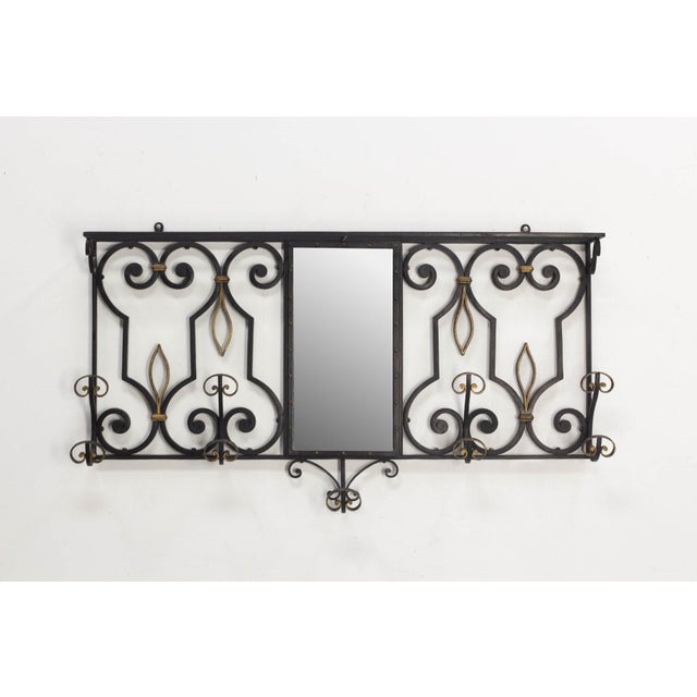 Black and gold wrought-iron wall-mounted coat rack with mirror, France, 1950s A French wall-mounted coat rack from the...