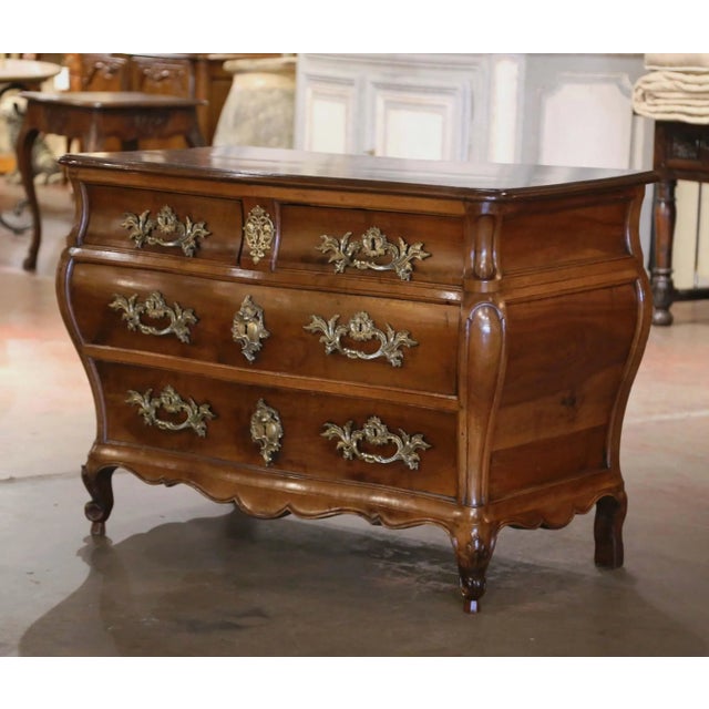 Crafted in Bordeaux, France circa 1760, this elegant antique “Commode Tombeau” exemplifies the graceful movement and...
