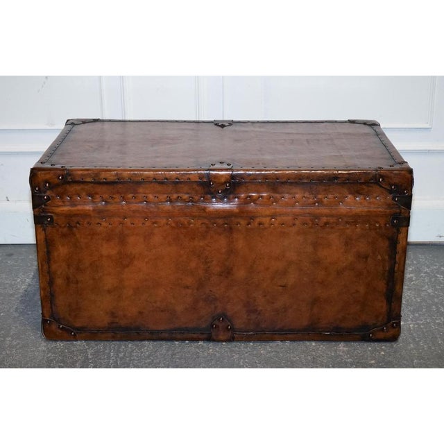 This striking vintage flat-top storage trunk has been fully restored and finished in hand-dyed brown leather, giving it a...