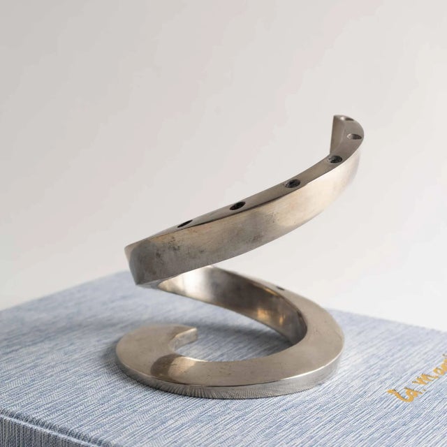 Sleek and sculptural 1960s-era candlestick holder crafted in silver-plated metal. Designed by renowned Swedish artist...