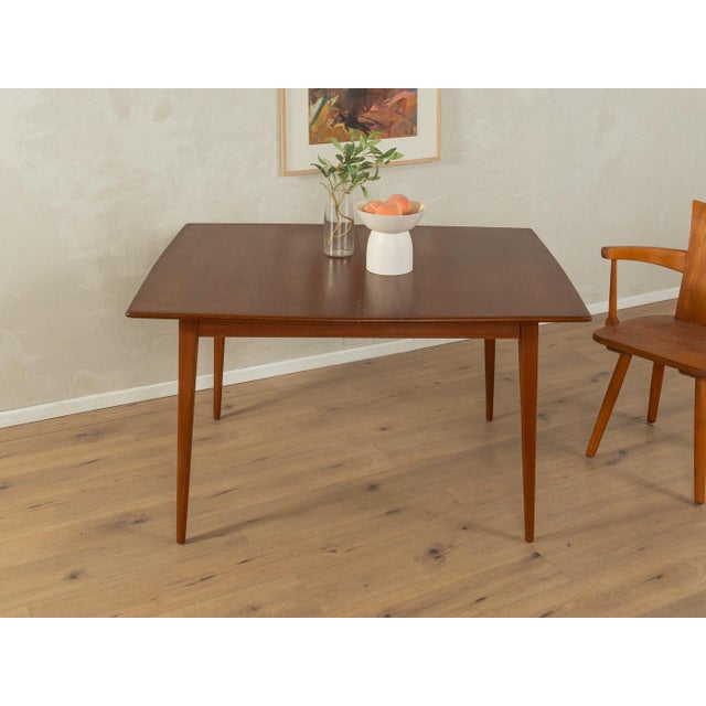 A wonderful butterfly dining table from the 1960s. Solid frame and veneered tabletop with solid teak edges. Quality...