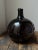 Large handblown demijohn bottle can a very unique bulb shape, circa early 19th C. Dark glass bottle of globular form in a...