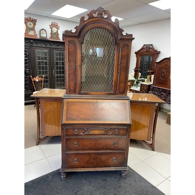 For sale is a unique antique secretary desk. The desk has a large front glass center door with a brass mesh screen behind...