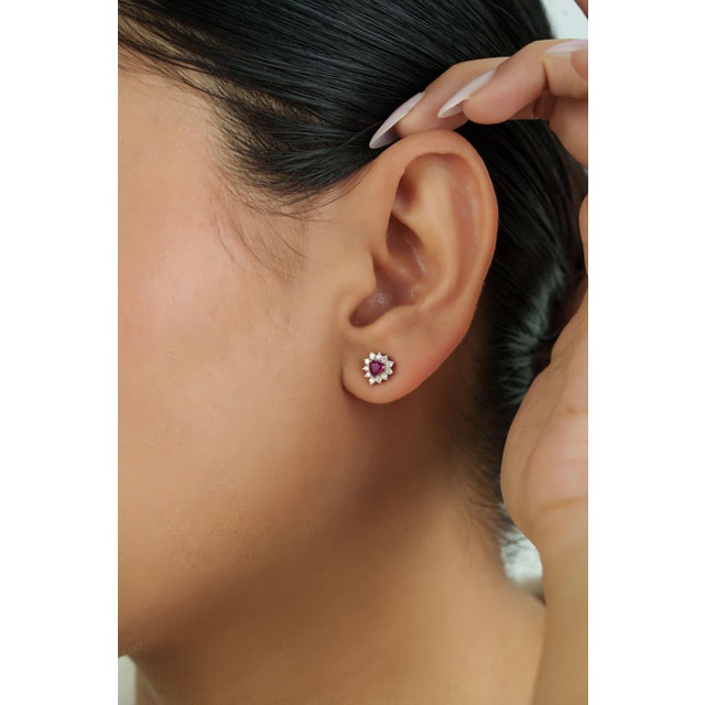 These stud earrings feature 0.57 carats of natural heart-cut rubies, set in 14K white gold. Each ruby measuring...