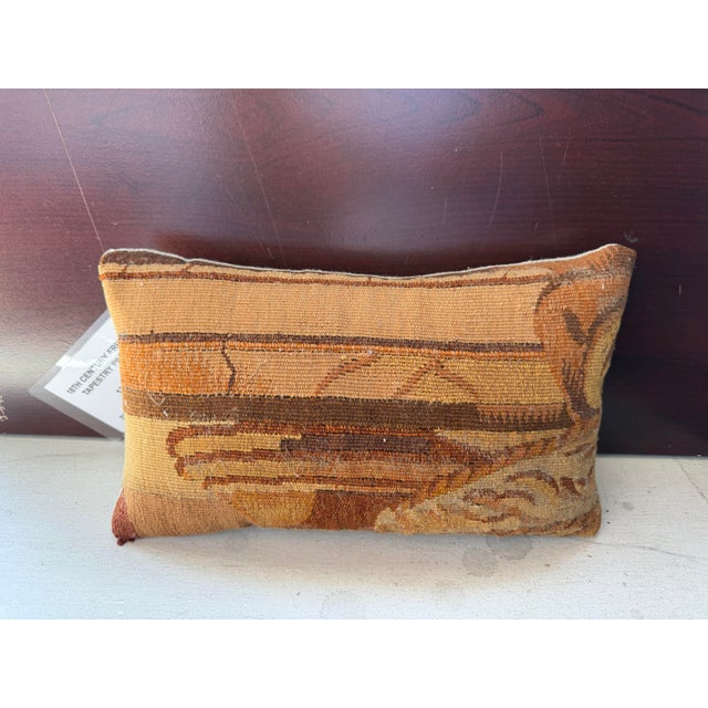 This antique pillow is created from a surviving fragment of an 18th-century French tapestry, preserving part of a much...