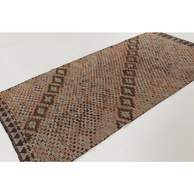 This vintage 5x10 Turkish kilim runner is a refined handwoven wool flatweave dating to circa 1950–1960. The piece features...