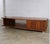 This striking mid-century modern coffee table features a low-slung, rectangular silhouette that instantly grounds a space...