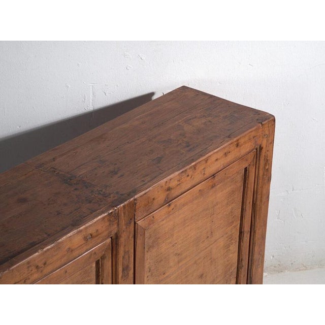 Tall chinese sideboard in carved pine, with a two-door, and two inner shelves, is decorated with geometric motifs,...