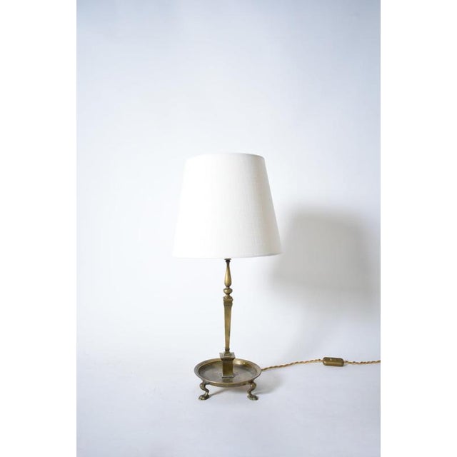 Quadripod lion paws bronze lamp, 1960s. Neoclassical bronze table lamp with a quadripode lion paws base supporting a plate...