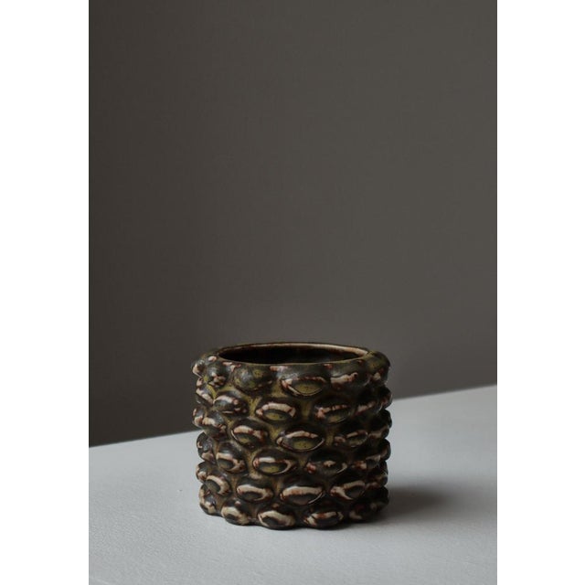 A richly textured stoneware cup by Axel Salto, model 20702, executed at Royal Copenhagen and finished in Salto’s...