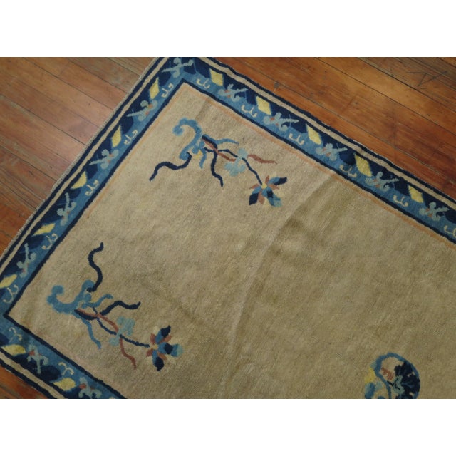 Long 1920s Chinese runner with a solid open field design with floral motifs in beige with a lovely floral border in navy...