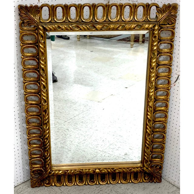 Hollywood Regency gilt ring motif mirror, with inset 35" x 23" beveled mirror, with continuous gilt pierced oval rings
