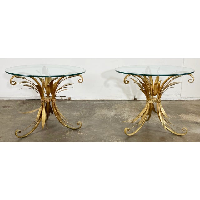 Classic vintage Hollywood Regency style sheaf of wheat side tables with rich gilt finish and round glass tops. Feature...