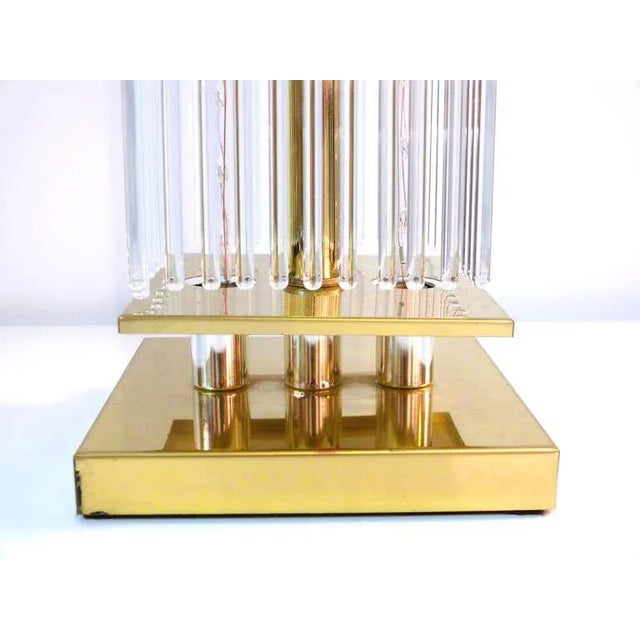 Brass lamp for Lightolier with hanging glass rods all around. Lamp includes two lighting rods visible through the glass to...