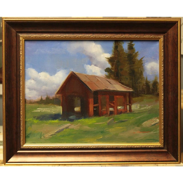 This oil on canvas depicts the remnants of an old house, its weathered red exterior set against a backdrop of lush...