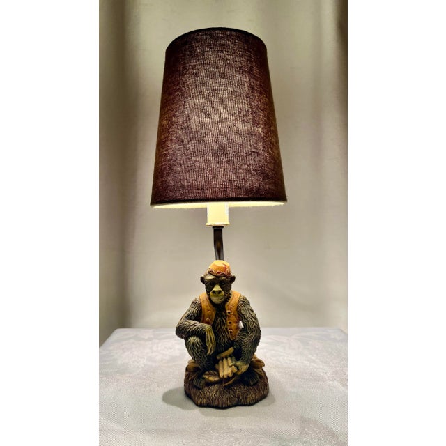 This Vintage Monkey Wearing Fez Accent Lamp with a green shade is a delightful piece manufactured by CBK in 1999. The...