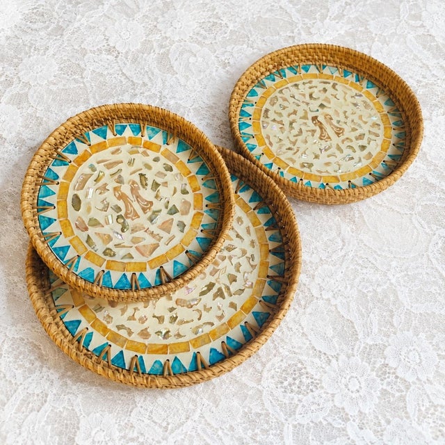 This set of three round trays is handmade with rattan and mother-of-pearl inlay. Natural rattan is woven to form a rounded...
