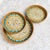 This set of three round trays is handmade with rattan and mother-of-pearl inlay. Natural rattan is woven to form a rounded...