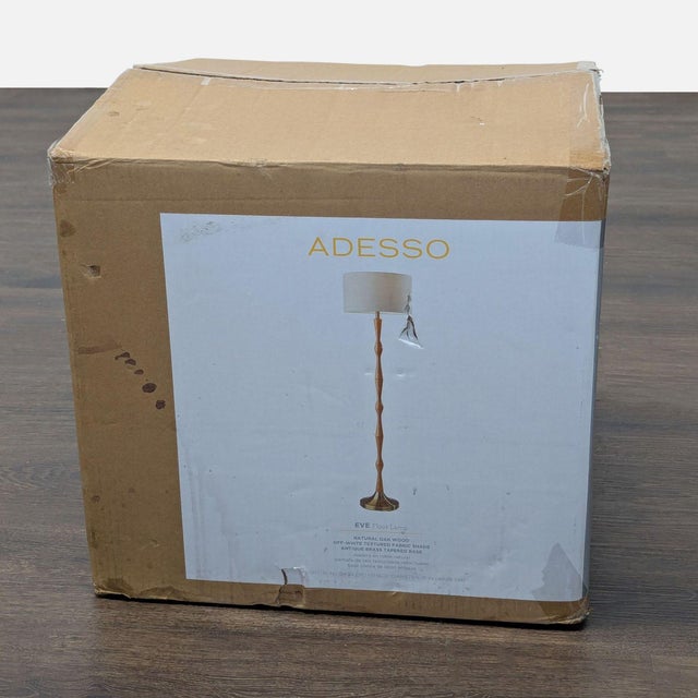 Brighten your space with the Adesso Eve Floor Lamp. This lamp features a natural oak wood stand and a simple white fabric...