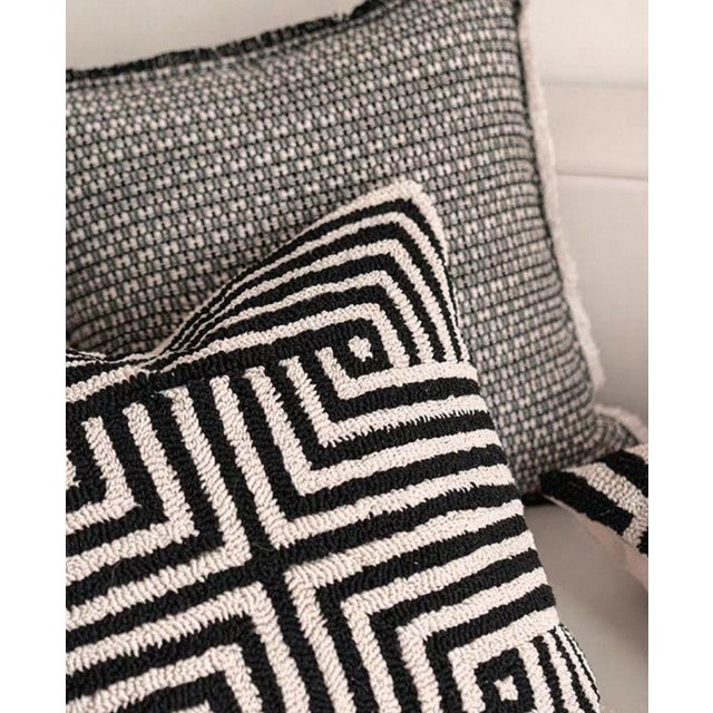 This throw pillow is a visually striking piece of home art, featuring a classic black and white color scheme. It is...