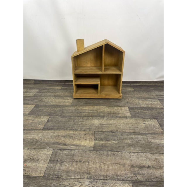 Indian rosewood bookcase. This wooden bookcase, shaped like a house, is crafted from a warm wood tone. It features several...