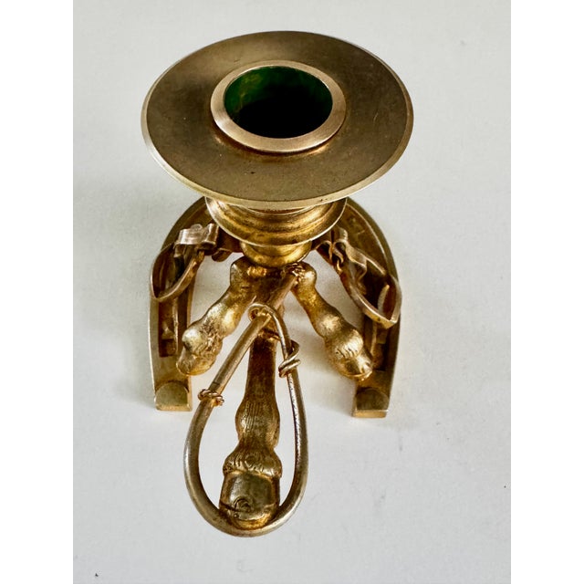 Charming and finely crafted candle holder made of cast brass or bronze and gilded. The base is a horseshoe, with detailed...