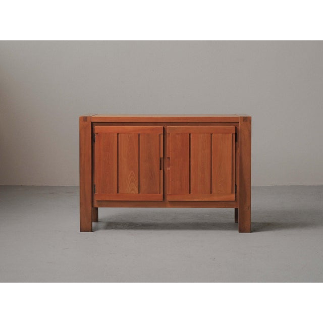 Low sideboard, produced around 1980, crafted from solid elm and elm veneer. Opening through two vertically paneled doors,...