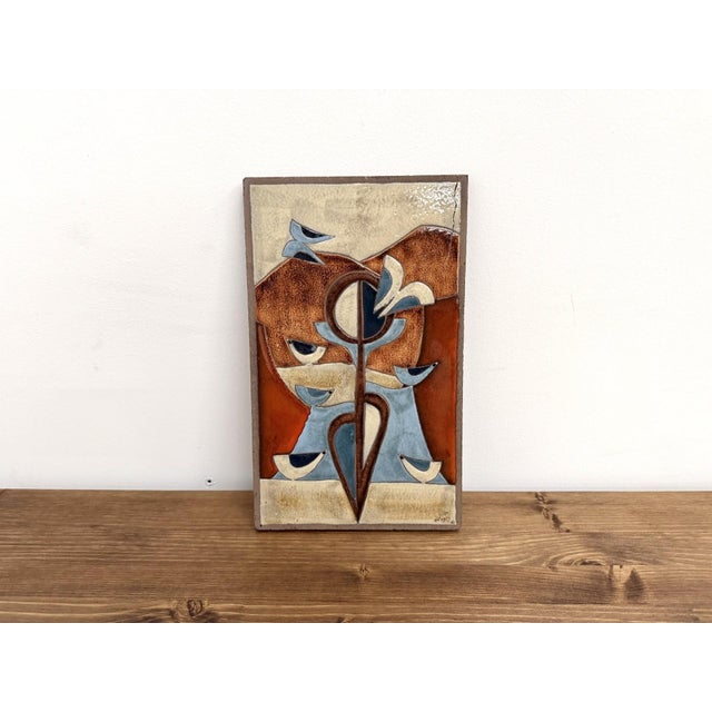 Vintage wall plaque in thick chamotte stoneware, decorated with an abstract and stylized design evoking a plant or sun...
