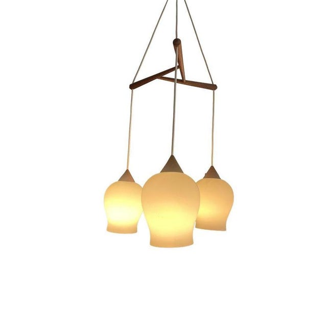 Scandinavian mid-20th century pendant lamp A Scandinavian lamp with a triangular centerpiece of teak-stained wood,...