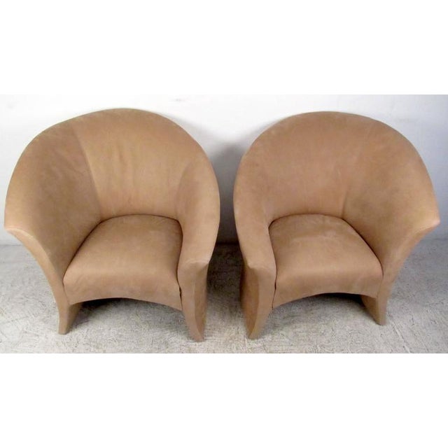 This stylish pair of vintage modern lounge chairs feature comfortable tan suede upholstery, manufactured by iconic makers...
