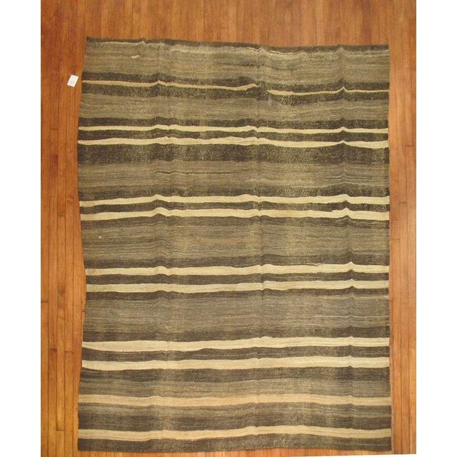 A midcentury Turkish Kilim. Charcoal, brown, ivory. Measures: 7'2" x 10'.