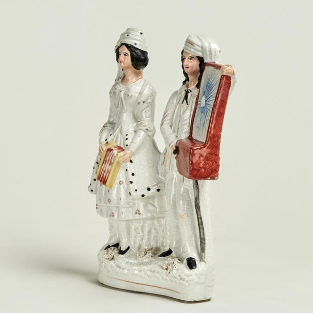 Unusual 19th century English Staffordshire musical figures crafted in porcelain and hand decorated depicting a female...