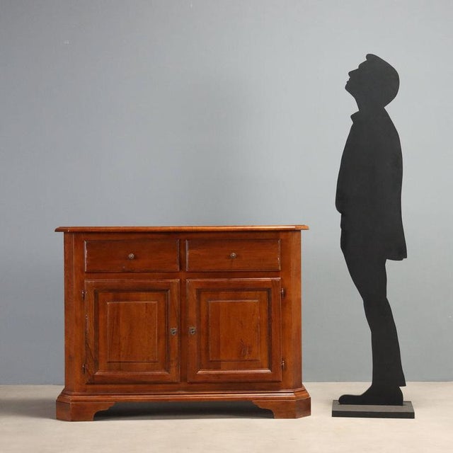 Walnut sideboard from the first half of the 20th century, originating from Italy, featuring a slight scalloping that adds...