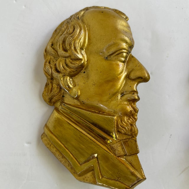 Pair of decorative brass presidential commemorative medallions: John Quincy Adams and John Adams II.