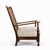 A characterful colonial-style armchair featuring a woven wicker (cane) back panel set within a solid dark-stained wooden...