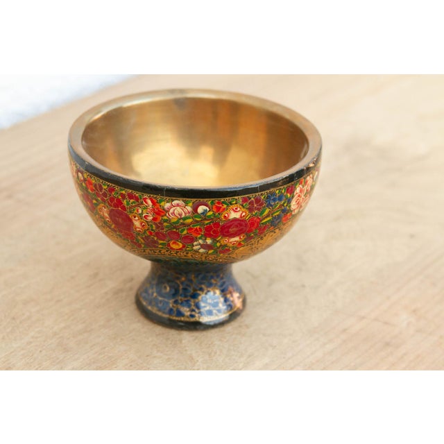 A jewel-toned masterpiece from the Kashmir Valley, this small footed bowl is defined by its lush, hand-painted floral...