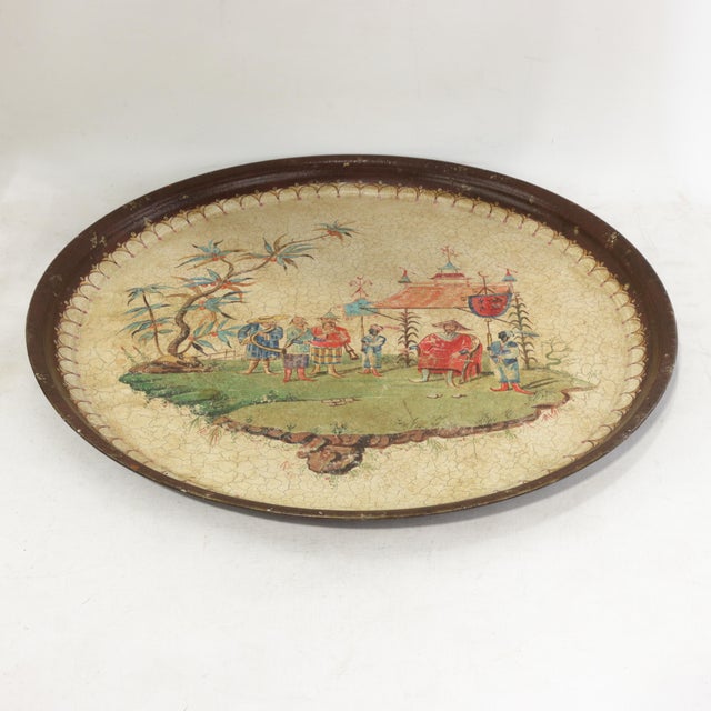This captivating vintage round tole tray features a warm, antiqued cream lacquer finish that serves as a canvas for a...
