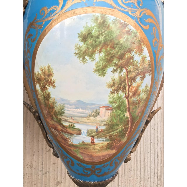 A pair of large 19th century French Sevres ormolu-mounted and painted vases. Each in baluster form with large ormolu...