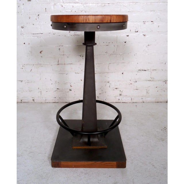 Unique vintage modern stool featuring a square wood base, round iron foot rest, and a solid wood seat. Dimensions: 14W x...