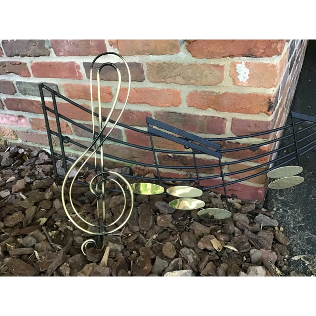 This unique vintage metal wall hanging by Curtis Jere is in the shape of a piece of music showcasing a treble clef and...