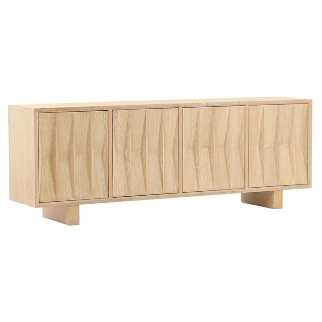 Natural light oak wood sideboard / buffet. Carved elongated diamond subtle designs on each of the four doors. Each cabinet...