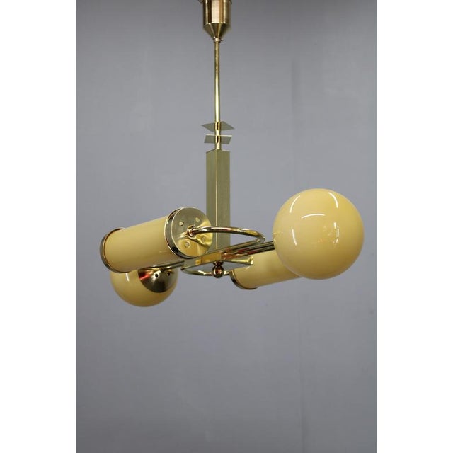 Exceptional art deco chandelier manufactured in czechoslovakia in the 1930s, crafted in brass and fitted with two rounded...